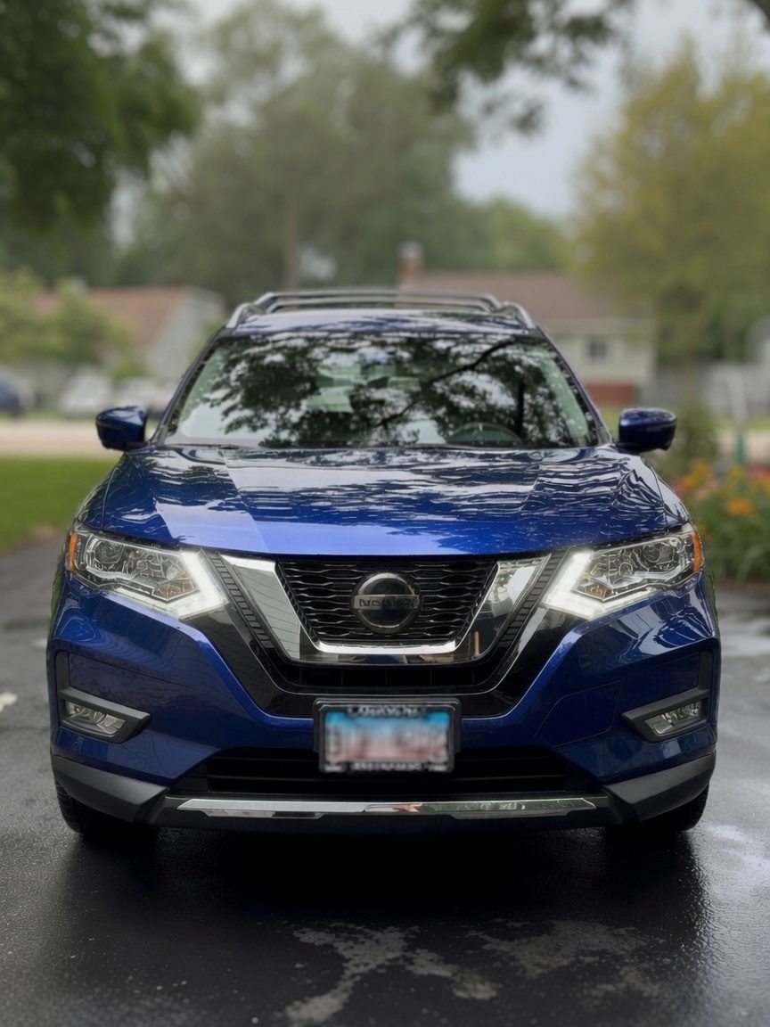 Blue Nissan Rogue front end after an exterior detail, paint and grille spotless